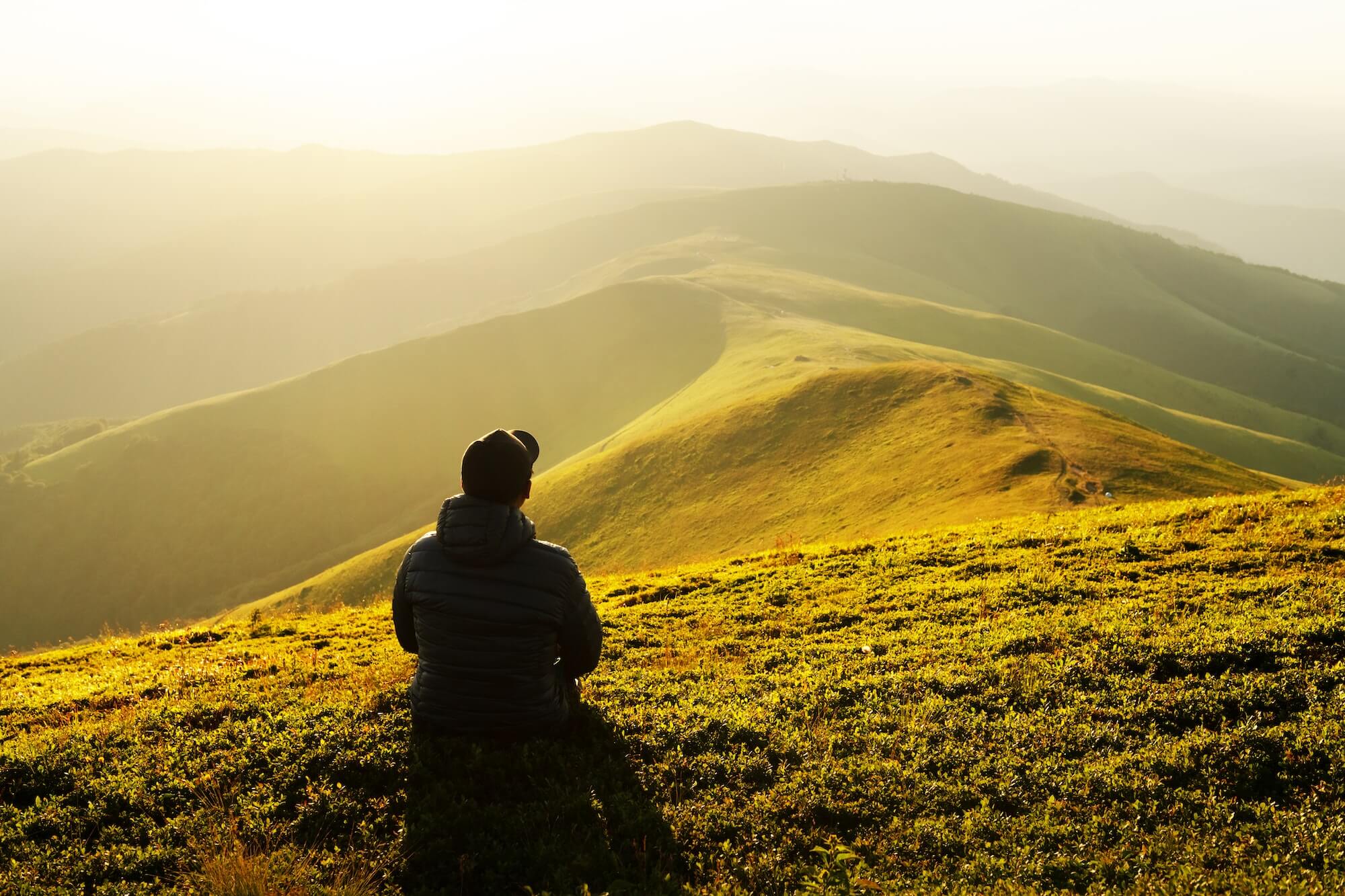 Alone tourist on the edge of the mountain hill